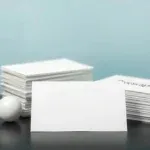 Close up of various specialty business cards showcasing metallic, plastic, kraft, hemp, and bamboo paper textures and colors.